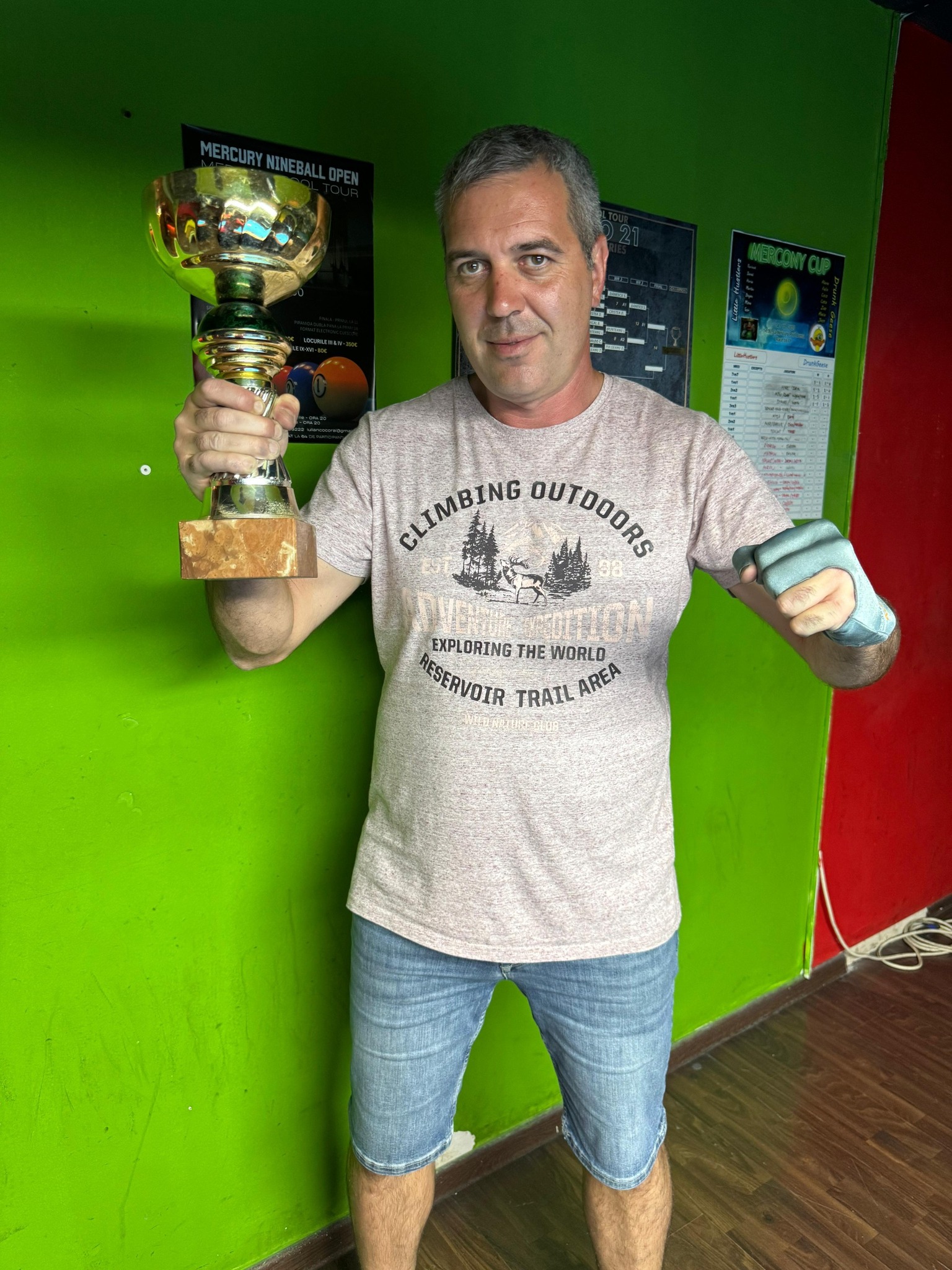 Câștigător de turneu cu trofeul ridicat, atmosferă de echipă