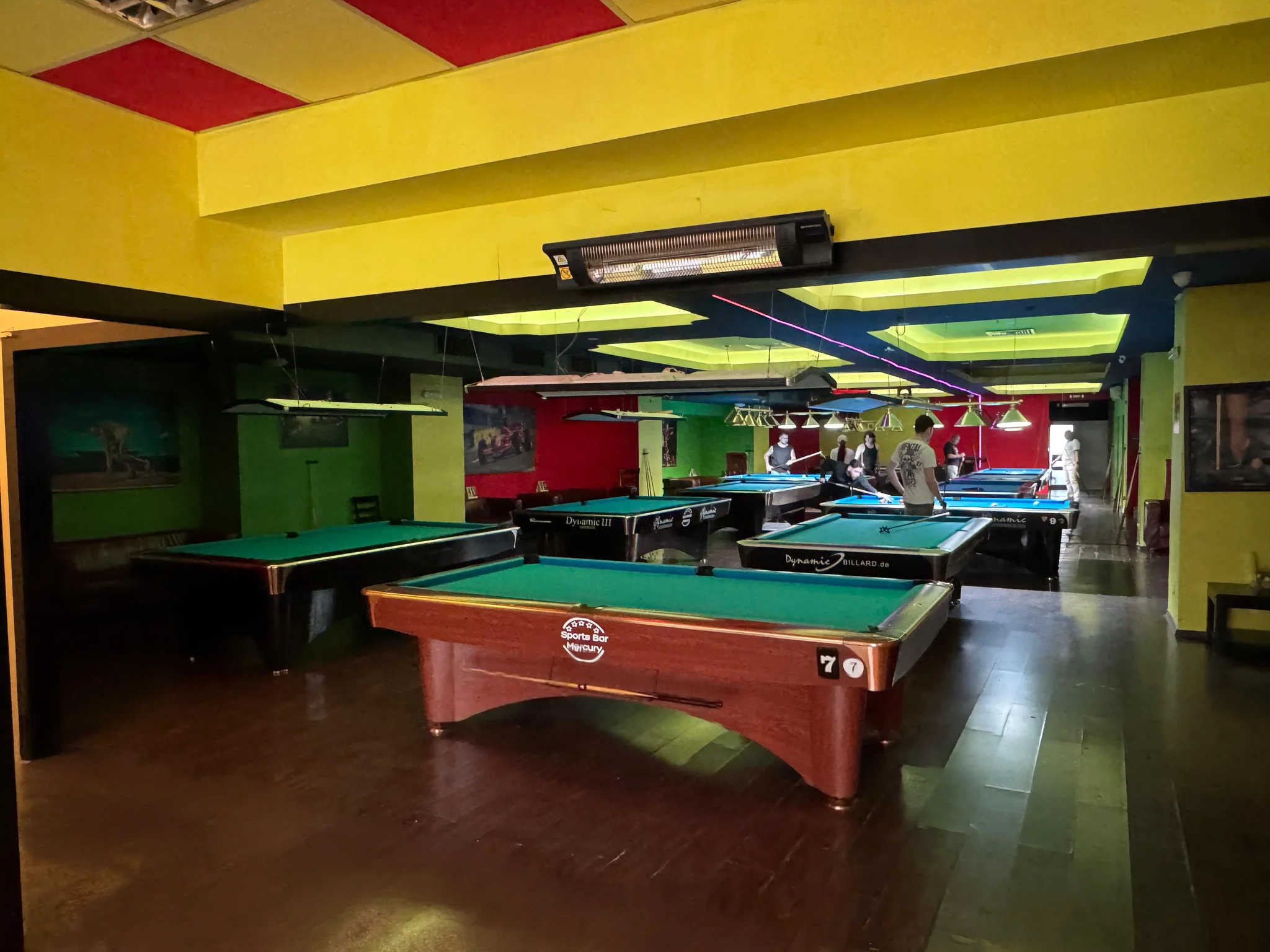 Sala Mercury cu mesele de biliard și câțiva jucători la mesele din fund