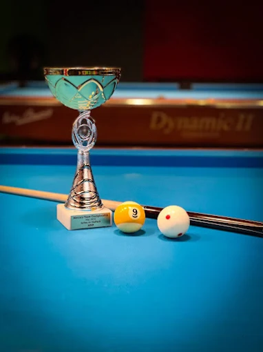 Table detail with trophy and cue, 9-Ball setup
